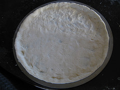 Pizza crust spread with creamy white sauce