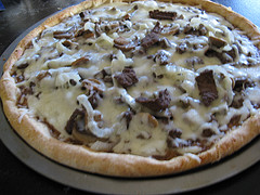 Whole steak pizza topped with steak strips and cheese