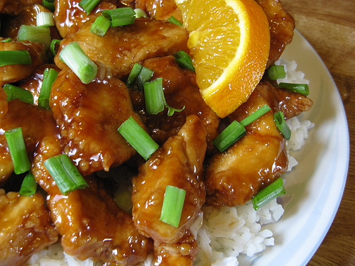 Orange chicken with green onions served over white rice
