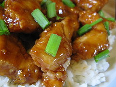 Orange chicken with green onions served over white rice