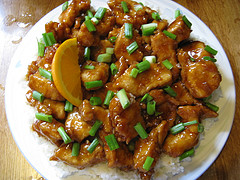 Orange chicken with green onions served over white rice