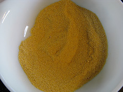 Bowl of yellow cornmeal breading for Cajun tilapia
