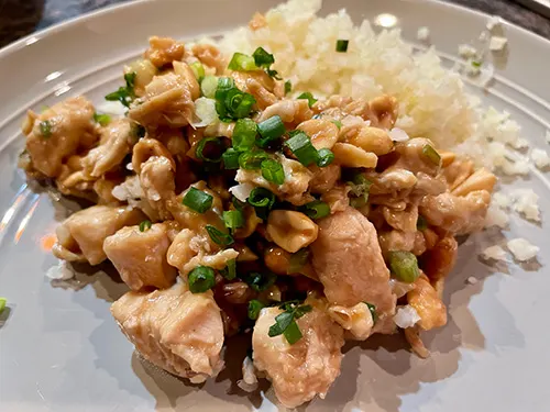 Close up view of Kung Pao chicken on a plate.