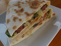 Grilled steak quesadilla cut into wedges on a white plate