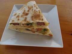 Grilled steak quesadilla cut into wedges on a white plate