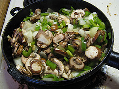 Skillet with mushrooms, onions, and green peppers cooking