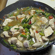 Moo goo gai pan cooking in a skillet with vegetables and chicken