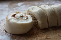 Bread machine cinnamon roll dough, rolled up and sliced.
