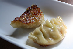 Crispy pot stickers with browned edges on a white plate