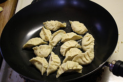 Pot stickers frying in a skillet