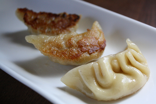 Crispy pot stickers with browned edges on a white plate
