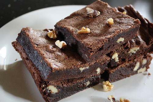 Stack of chocolate brownies with nuts on a plate