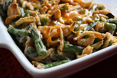 Green bean casserole topped with crispy fried onions in a white baking dish