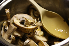 Sliced mushrooms in a pot with a spoon and broth