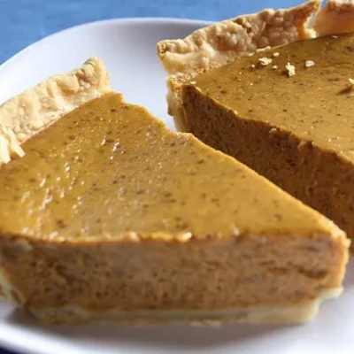 Two slices of prepared pumpkin pie recipe on a plate.