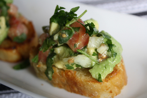 Guacamole bruschetta with diced tomato and avocado on bread