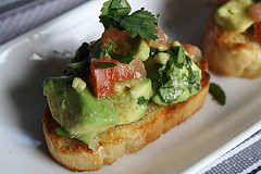 Guacamole bruschetta with diced tomato and avocado on bread