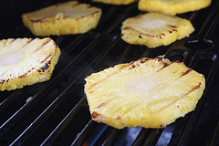 Grilled pineapple slices cooking on a grill