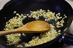 Minced garlic and ginger cooking in a skillet.