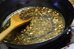 Garlic ginger sauce simmering in a pan with a wooden spoon.