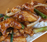 Mongolian chicken with crispy strips and onions over white rice