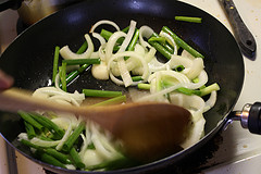 Onions and green onions stir frying in wok