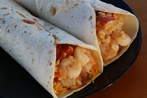 Shrimp burritos with melted cheese and rice inside