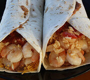 Shrimp burritos with melted cheese and rice inside