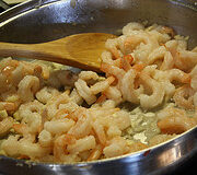 Shrimp cooking in a skillet with garlic and butter