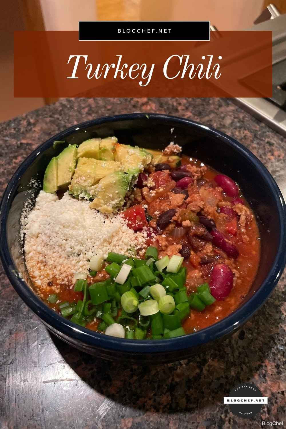 Prepared turkey chili with green onions, cotija cheese, and avocado.