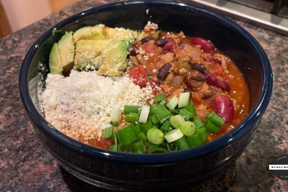 Prepared turkey chili with green onions, cotija cheese, and avocado.