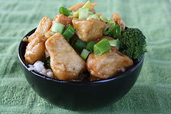 Crispy chicken pieces topped with green onions in a bowl