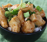 Crispy chicken pieces topped with green onions in a bowl