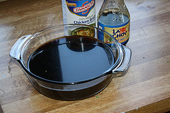 Soy sauce and rice wine vinegar bottles with a bowl of soy sauce
