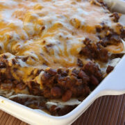 Baked burrito casserole with melted cheese on top in a white dish