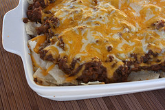Baked burrito casserole with melted cheese on top in a white dish