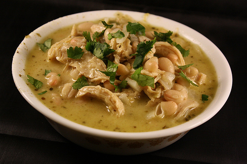 Bowl of white chicken chili topped with fresh cilantro