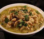Bowl of white chicken chili topped with fresh cilantro