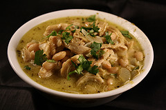 Bowl of white chicken chili topped with fresh cilantro