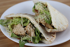 Chicken caesar pita halves on a white plate