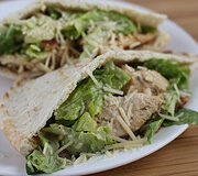 Chicken caesar pita halves on a white plate