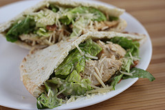 Chicken caesar pita halves on a white plate