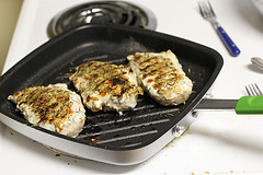 Grilled chicken pieces cooking on a grill pan