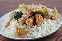 Chicken in garlic sauce served over white rice with broccoli and sesame seeds