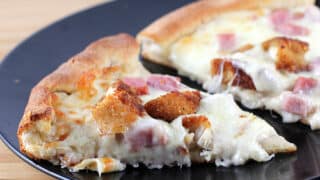 Prepared chicken cordon bleu pizza on plate.