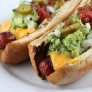 Nacho dogs topped with cheese guacamole and jalapeños