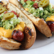 Nacho dogs topped with cheese guacamole and jalapeños
