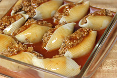 Cheesy taco stuffed pasta shells with seasoned beef and salsa in a baking dish