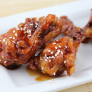 Teriyaki glazed chicken wings served on a white rectangular plate.