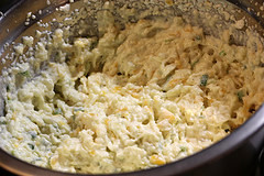 Bowl of mashed potato mixture with cheese and green onions before stuffing